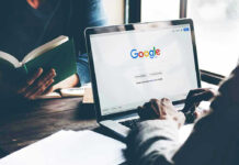 Laptop on Google homepage person reading a book