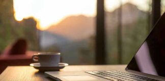 Laptop coffee cup and phone on wooden table
