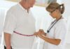 Shocking Shift: Health Pros Ditch Weight Loss Focus A healthcare professional measuring a patients waist with a tape measure