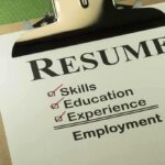 A resume checklist on a clipboard highlighting skills, education, experience, and employment